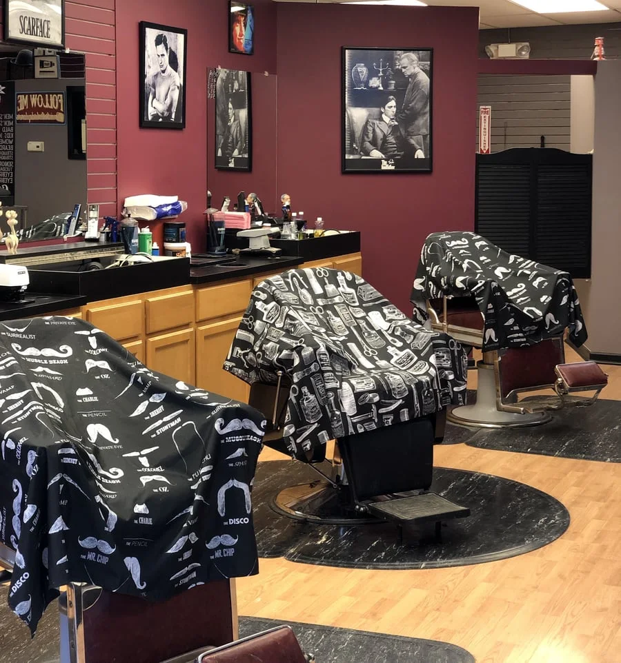 Inside Main Street Barbershop — chairs, capes and framed prints